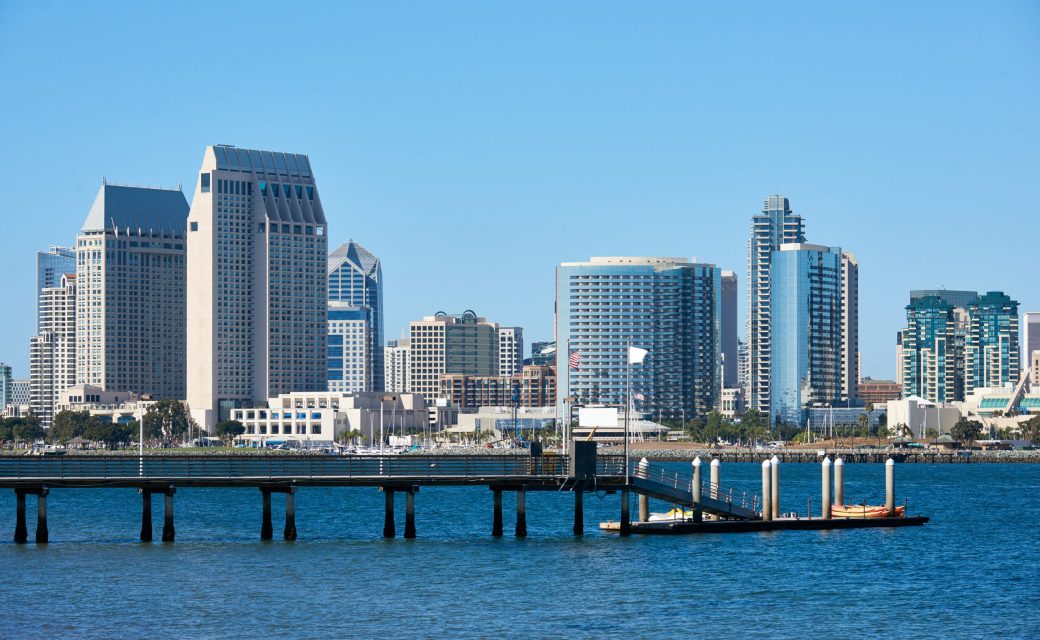Pier with kayak boats, downtown skyline on background. San Diego, California